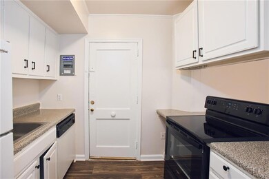 Kitchen with white appliances, dark wood-type floo