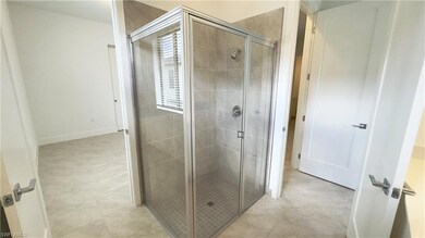 Bathroom featuring a stall shower and light tile patterned floors