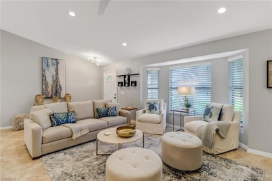 Living area with light tile patterned flooring, recessed lighting, and lofted ceiling