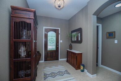 The front door is 3/4 light emblessished with a Te