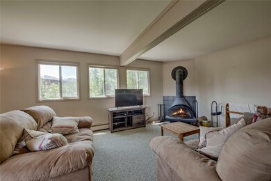 Carpeted living room featuring beam ceiling, a bas