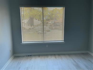 Unfurnished room with baseboards and light wood-type flooring
