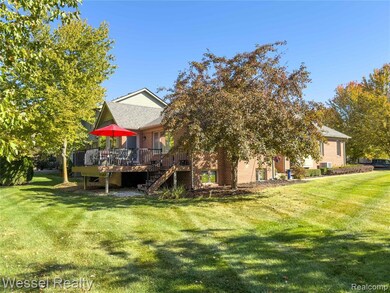 Rear view of property featuring a wooden deck, a yard, stairs, brick siding, and roof with shingles