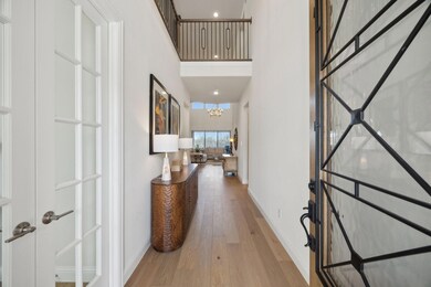 Hallway with a notable chandelier, baseboards, a h