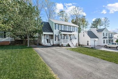 Colonial home featuring a porch, fence, a front ya