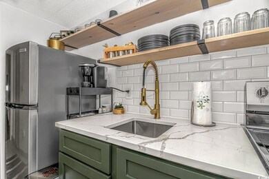 Kitchen with sink, light stone counters, a texture
