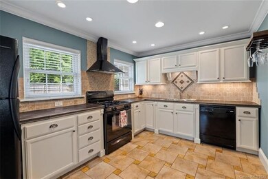 Bright and airy kitchen features gas range and bla
