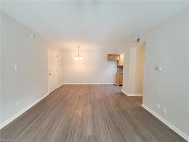 View towards dining room and kitchen. New vinyl flooring and light fixtures throughout.