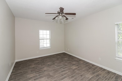 Empty room with wood finish floors and ceiling fan