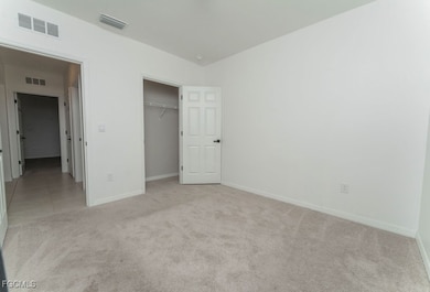 Unfurnished bedroom with light carpet and a closet