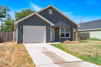 View of front facade featuring a garage and a front yard