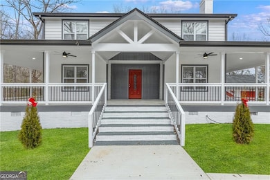 View of front of home with a ceiling fan, a porch, and a front lawn