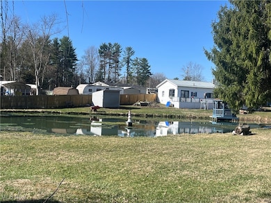 View of yard with a shed, a water view, an outdoor structure, and fence
