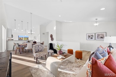 Living room with high vaulted ceiling, wood finished floors, recessed lighting, and a chandelier