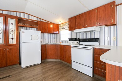 Kitchen with dark wood-type flooring, white applia