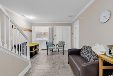 Sitting room with ornamental molding, washing machine and dryer, stairs, and a textured ceiling