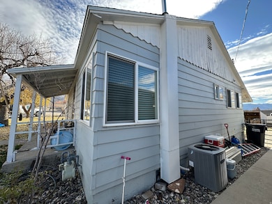 View of property exterior with a cooling unit and a cement driveway.