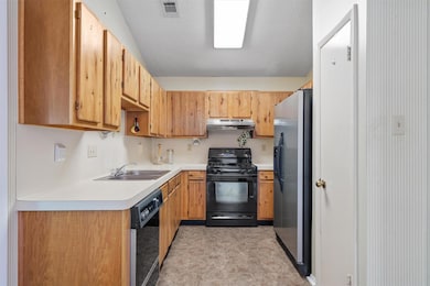 Kitchen featuring light countertops, a sink, a te