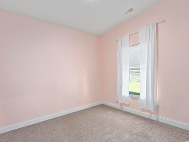 Carpeted empty room with baseboards and visible ve