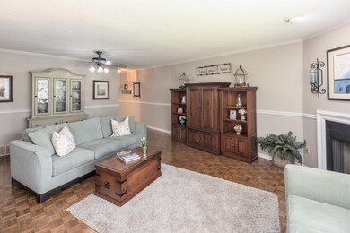 Living room with dark parquet flooring, crown mold