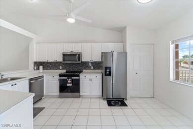 Kitchen with stainless steel appliances, lofted ceiling, backsplash, light countertops, and a ceiling fan