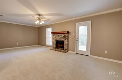 Unfurnished living room with ornamental molding, carpet, a brick fireplace, and ceiling fan