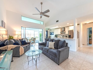 Tiled living room featuring high vaulted ceiling a