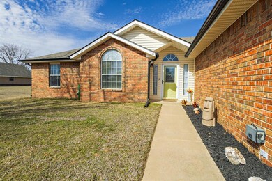 Entrance to property featuring a yard and brick si