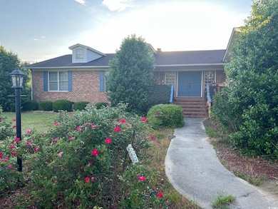 View of front of house with brick siding and roof with shingles