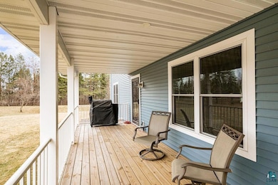 Wooden deck featuring a porch and a grill
