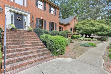 Property entrance featuring brick front and brick stairs