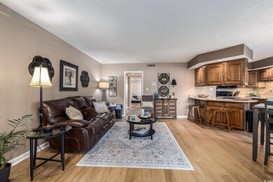 Living room featuring light wood-type flooring and a textured ceiling