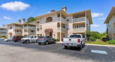 View of apartment building / complex with uncovered parking