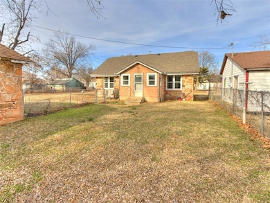 Back of property featuring central AC unit and a lawn