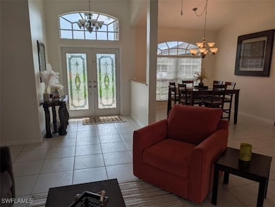 Entrance foyer with a chandelier, baseboards, fren