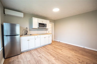 Kitchen with white cabinets, light wood-style floo