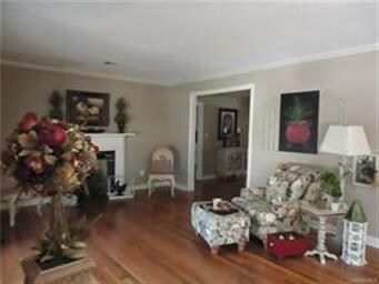 Living room with original wood floors and fireplac
