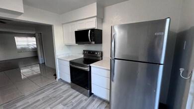 Kitchen with white cabinetry, light stone countert