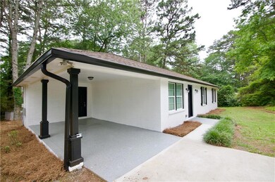 Ranch-style house featuring brick siding, a patio area, a front lawn, and a carport