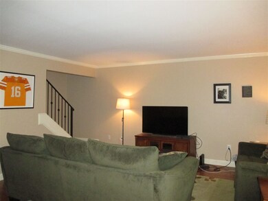 Opposite view of living room shows staircase to 2n