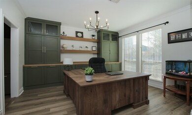 Here is a view of the dining area that is currently being used as an office space. Behind the desk are custom built-ins with hidden wine rack on the left side, custom paint and so much storage!