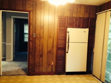 Far end of kitchen has recessed refrigerator surro