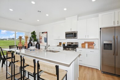 (Photo of decorated model, actual home's finishes will vary) Enjoy plenty of seating at the kitchen island and dining are adjacent to the kitchen.