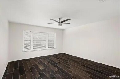 Empty room featuring ceiling fan, wood finished floors, and baseboards
