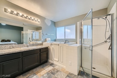 Bathroom with a stall shower, vanity, a garden tub