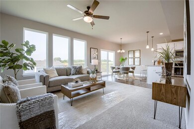 Living room with ceiling fan with notable chandelier, light hardwood / wood-style floors, and sink