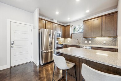 Kitchen with light stone countertops, a sink, sta