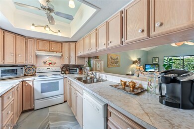 Kitchen featuring white appliances, a raised ceili