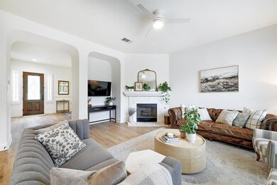 Living area featuring a ceiling fan, light wood f