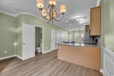 Kitchen featuring crown molding, a chandelier, light wood-style flooring, a peninsula, and recessed lighting